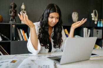 A Woman in White Long Sleeves Using a Laptop