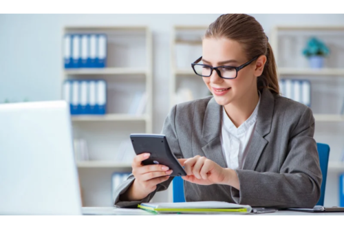 An accountant using calculator at office desk.