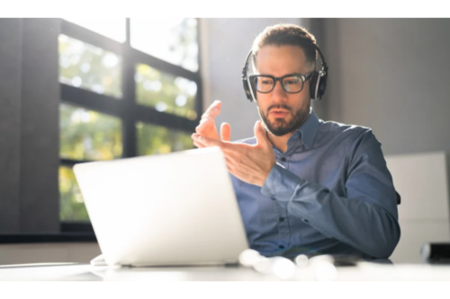 A professional in headphones having a video call on laptop