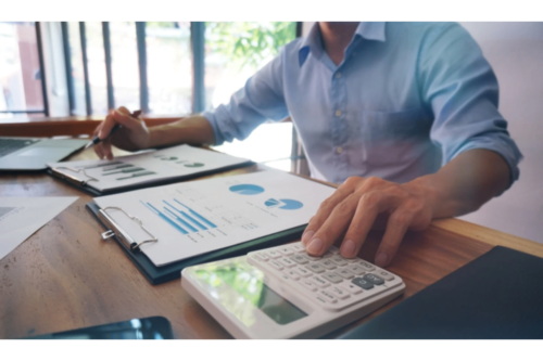 A CFO analysing financial charts with calculator and clipboard